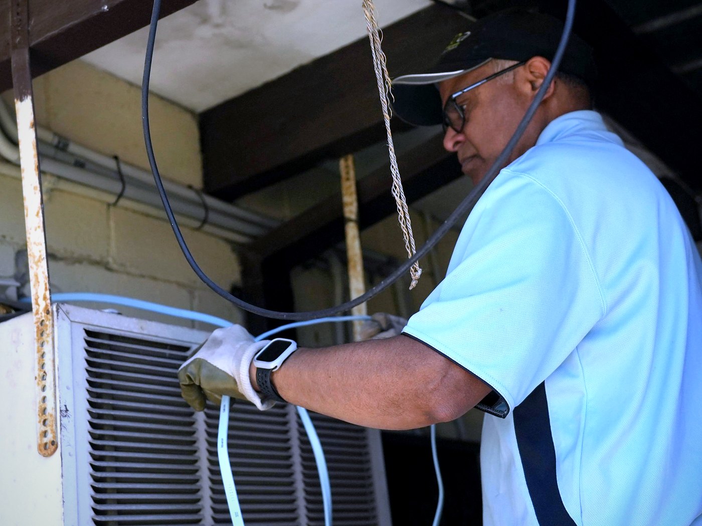 Vivek Refrigeration technician servicing an air conditioning unit